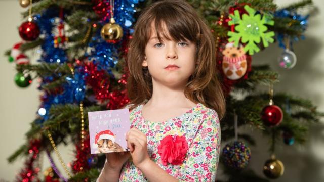 伦敦女孩弗洛伦斯·维迪科姆拿着她买到的Tesco套装圣诞卡（22/12/2019）