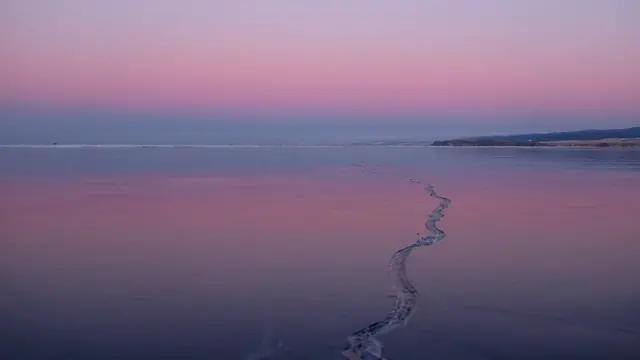 A long crack in the middle of the lake extending out of shot