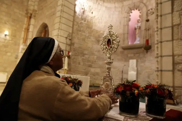 Монахиня перед реликвией