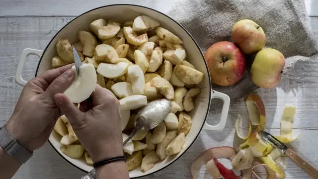 Женщина чистит яблоки