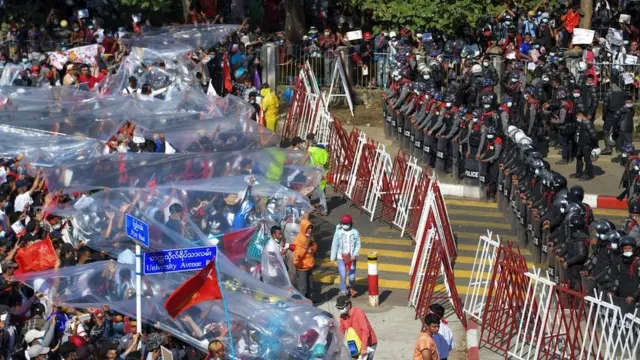 Algunos manifestantes protestaron bajo plásticos para protegerse de los cañones de agua.