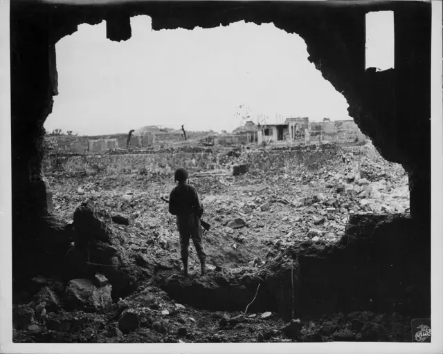 US Marine Rifleman viewing the results of US bombardment of Naha, during the Pacific Campaign of World War Two, Okinawa, Japan, circa 1943-1945.