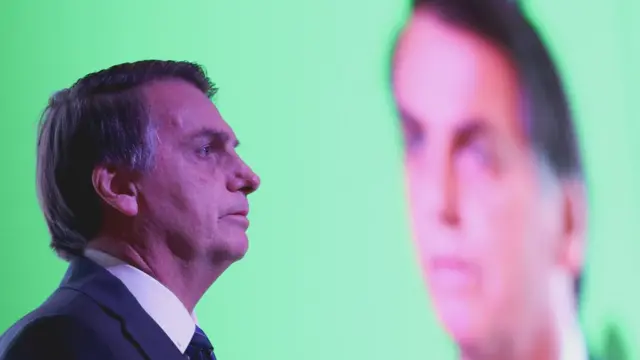 Bolsonaro aparecepix bet casinoperfil e, atrás, compix bet casinoimagem projetada no telão