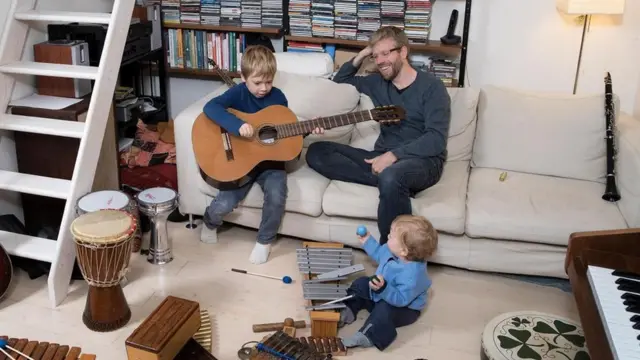 Pai brincando com os filhos em casa