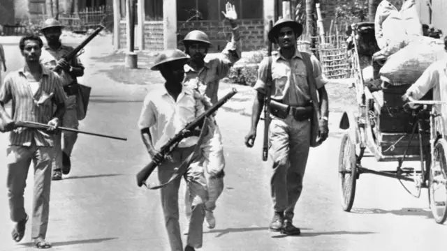 Uniformed East Pakistan rebel forces with armed civilians patrol a street in Jessore, East Pakistan on April 2, 1971