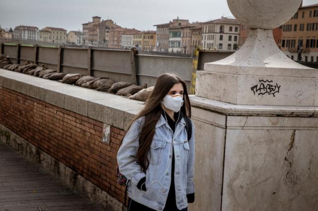 Mujer con mascarilla en Pisa, Italia.
