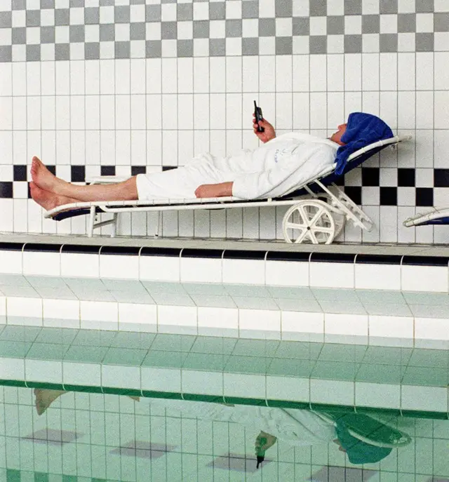 novinar pored bazena sa telefonom