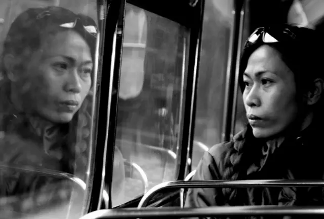 Una mujer mira por la ventana en un autobús.