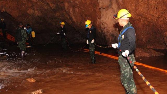 Thai military carrying equipment into the cave