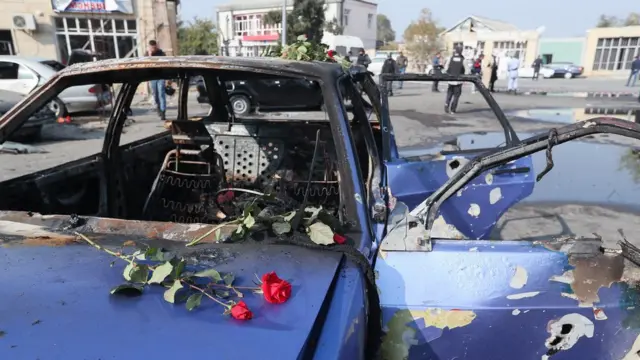 Bərdəyə edilmiş raket hücumu nəticəsində zərər görmüş avtomobilin üzərində güllər