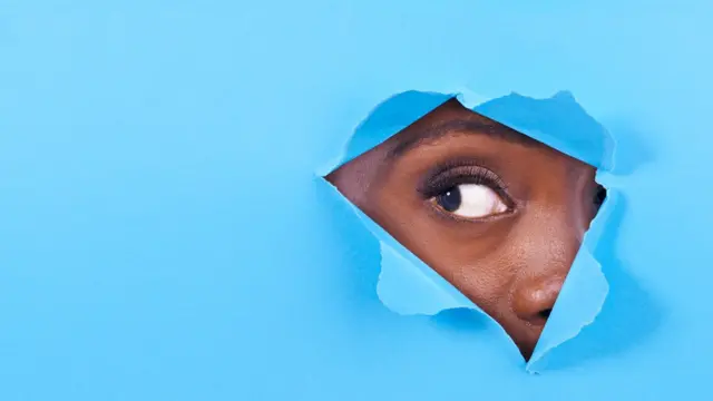 Mujer mirando por un agujero.