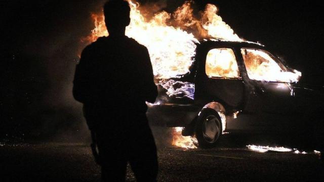 Carro pegando fogo durante protesto