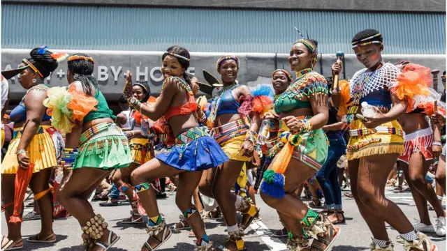 Des femmes dans leurs tenues traditionnelles chantent et dansent dans les rues lors du festival culturel Indoni SA, le 14 décembre 2018 à Durban, dans l'est de l'Afrique du Sud.