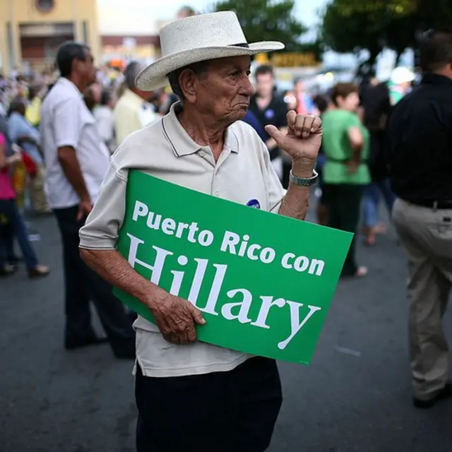 Hombre con un cartel que dice: "Puerto Rico con Hillary".