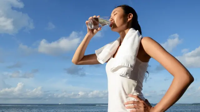 Femme boire de l'eau après le centre de remise en forme