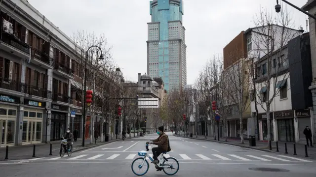 A man cycles along an empty street on February 8, 2020 in Wuhan, Hubei province, China.
