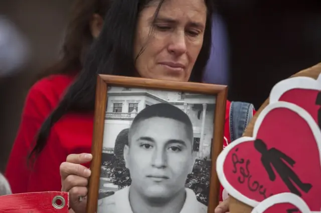 Mãe segura a foto do filho desaparecido