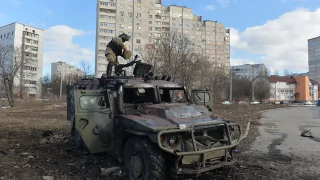 우크라이나 국토방위군 병사가 하르키우에서 불에 탄 러시아 차량을 둘러보고 있다
