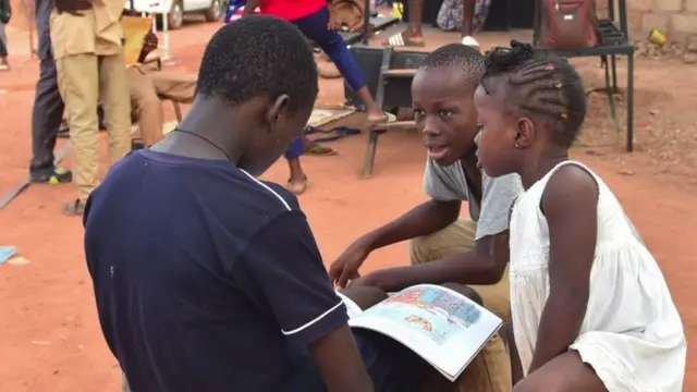 Des enfants en train de lire des livres à la librairie nomade de la 10ème édition du festival 'Les Récréatrales' à Ouagadougou (Burkina Faso) - 2018