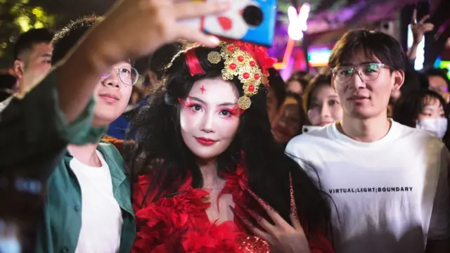 萬聖節晚上上海民眾與cosplay裝扮女生合照(中新社圖片31/10/2023)