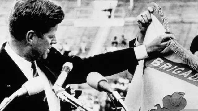 كينيدي يحمل علم المنفيين الكوبيين