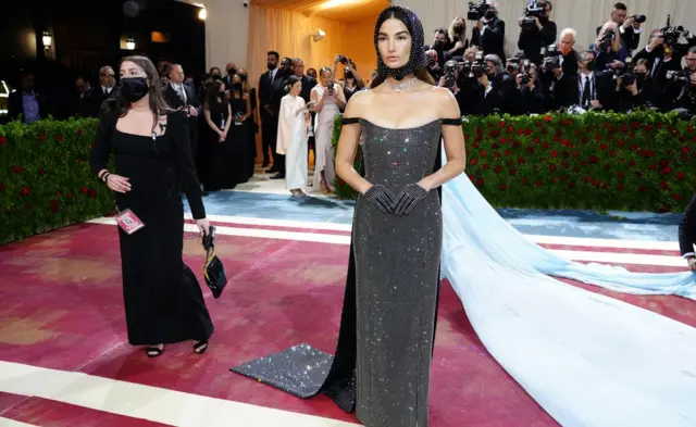 Umunyamideri Lily Aldridge yambaye ikanzu ndende ishashagirana n'ivara rirerire