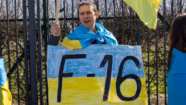Massa pro-Ukraina meminta Barat mengirimkan lebih banyak persenjataan ke Ukraina, termasuk jet tempur F-16, dalam demonstrasi di depan kantor NATO, 4 April 2023.
