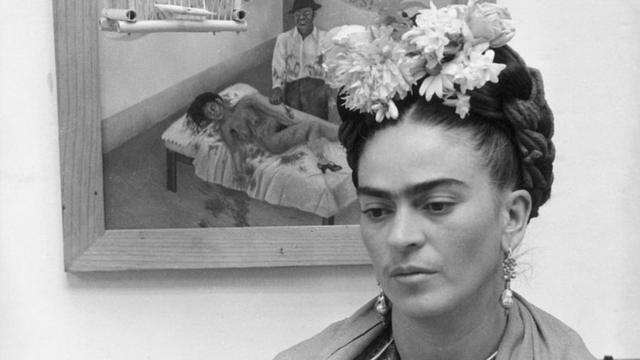 Frida Kahlo frente a uno de sus cuadros, "Unos cuantos piquetitos"