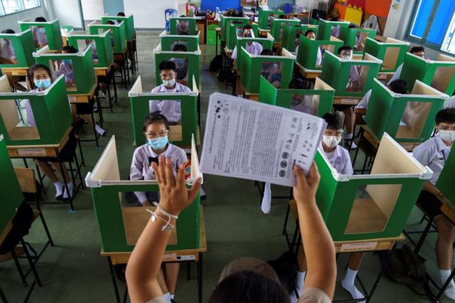 泰国学生在用投票箱改造的格子里上课。