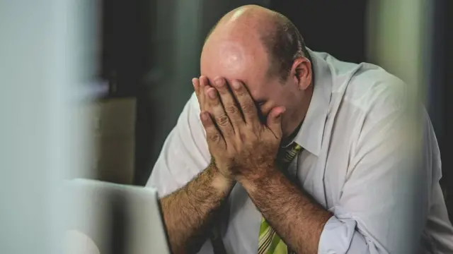 Un hombre con el rostro entre las manos