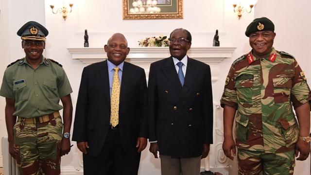 自宅軟禁中のムガベ大統領（写真右から2人目）と並んで写真撮影に応じるチウェンガ司令官（同右）（16日）