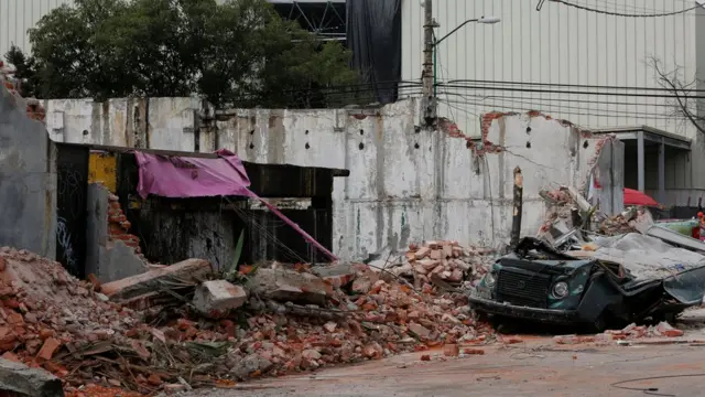 A damaged wall and a smashed vehicle are pictured after an earthquake in Mexico City