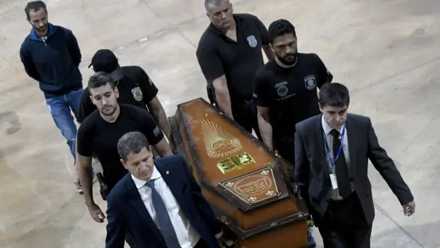 Policía cargando un ataúd.