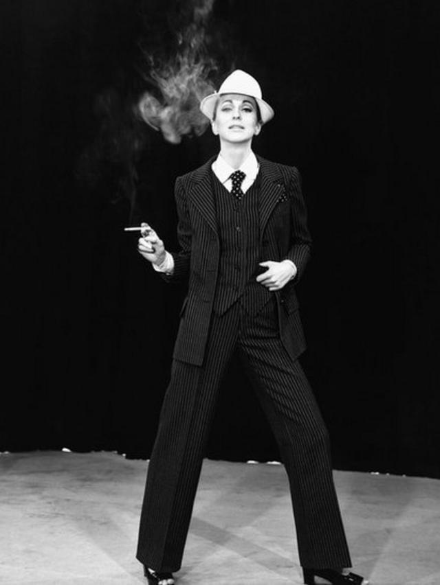 Modelo com cigarro aceso na mão usando um terno de três peças desenhado por Yves Saint Laurent na França, em 1967