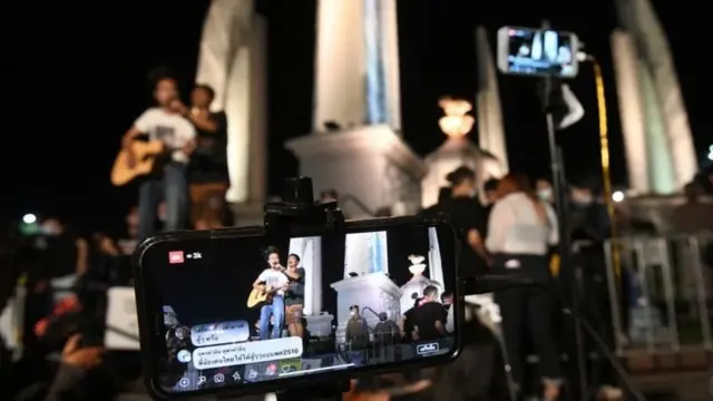 หน้าจอโทรศัพท์มือถือฉากหลังเป็นอนุสาวรีย์ประชาธิปไตย