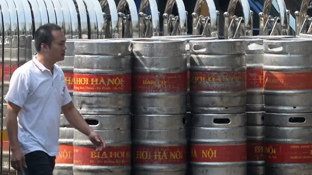 This picture taken on September 28, 2016 shows a man walking past kegs of beer at a brewery of the state-owned Hanoi Beverage Company Habeco in Hanoi.