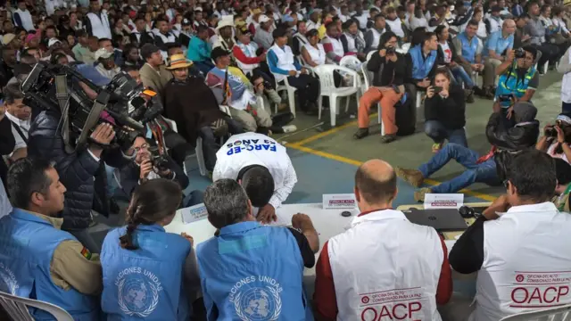 Guerrillero de las FARC formaliza la entrega de su fusil ante funcionarios de la ONU