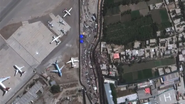 Imagem aérea mostra multidão e aviões