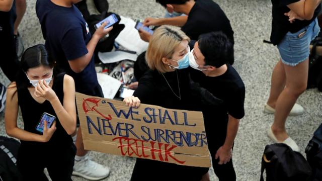 香港国际机场“反送中”集会一对示威男女隔着口罩接吻（10/8/2019）