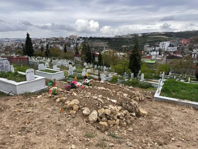 Yeni kazılmış mezarlar. Baş kısmında çiçekler var.