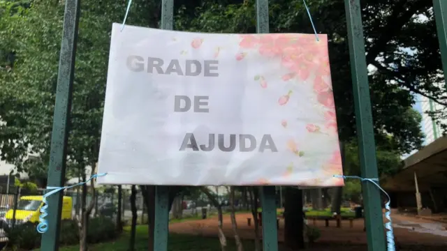 Placaarbety cnpjdoação com placa onde se lê "grade se ajuda"