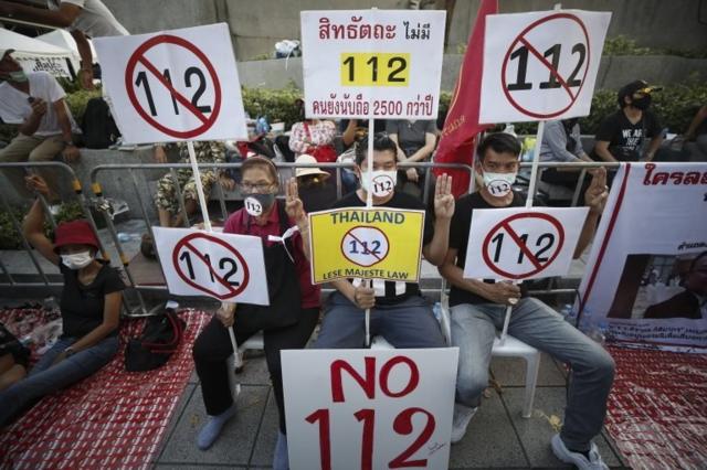 Anti-government protesters hold up placards during a rally calling to lift the section 112 of the Thai Criminal Code