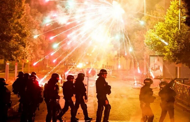 شماری پلیس در خیابانی شعله‌وربا معترضان برخورد می‌کنند