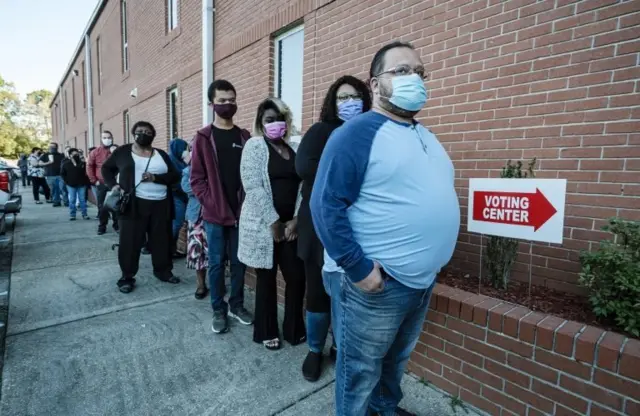 Voters wait in line at a polling location in a church in Mobile, Alabama, USA, 03 November 2020