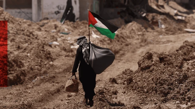 एक फ़लस्तीनी व्यक्ति वेस्ट बैंक में एक शरणार्थी शिविर के पास से गुज़रता हुआ