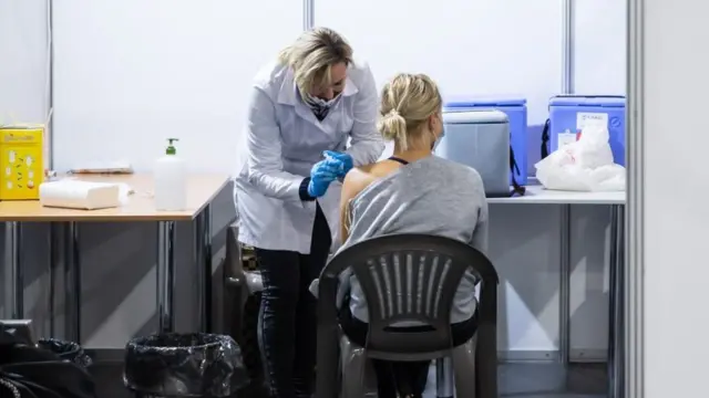 Медсестра робить щеплення жінці