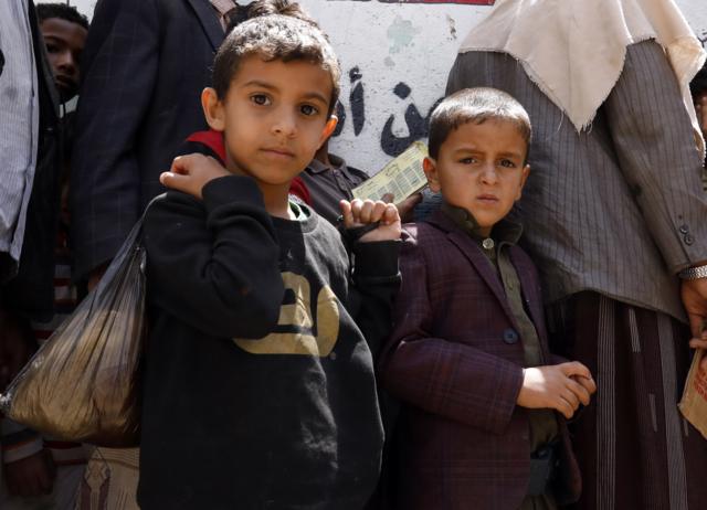 Yemeni children wait to get free food rations from a charity group in Sanaa, April 2020