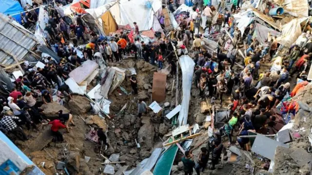 Personas en Gaza en torno a escombros tras bombardeos israelíes