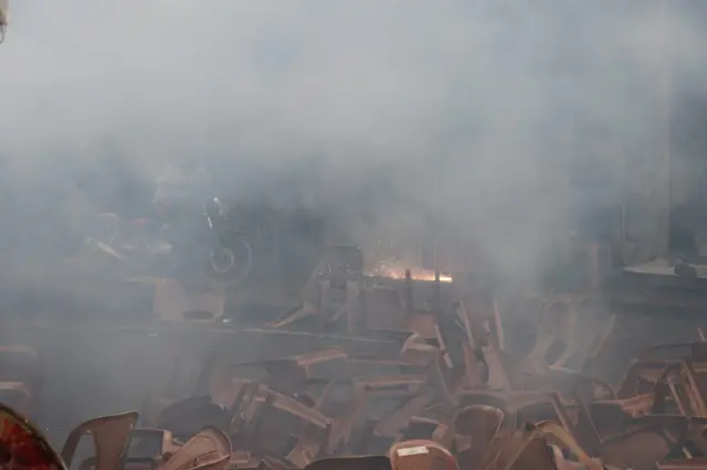 ধোঁয়াচ্ছন্ন রাস্তায় ভাঙাচোরা চেয়ার পড়ে আছে 