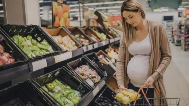 Mwanamke mja mzito akinunua mboga katika duka la jumla